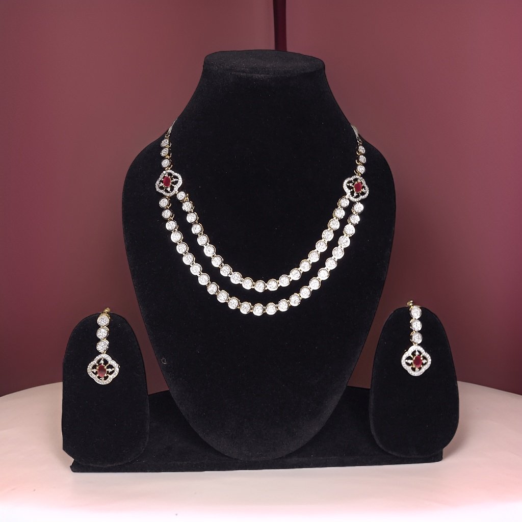 Make a bold statement with our Red Silver American Diamond Necklace. This eye-catching piece features sparkling red American diamond accents that catch the light beautifully. The adjustable length ensures a comfortable fit, making it suitable for all occasions.