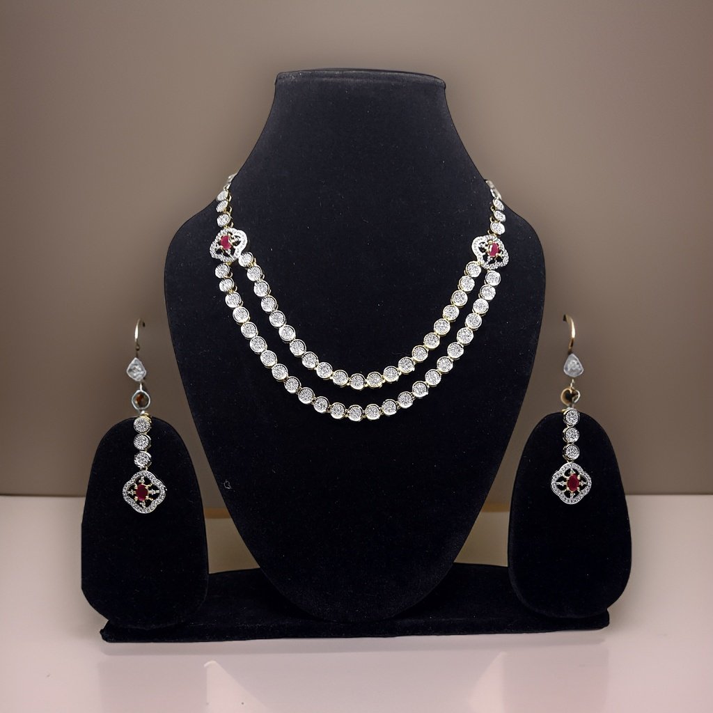 Make a bold statement with our Red Silver American Diamond Necklace. This eye-catching piece features sparkling red American diamond accents that catch the light beautifully. The adjustable length ensures a comfortable fit, making it suitable for all occasions.