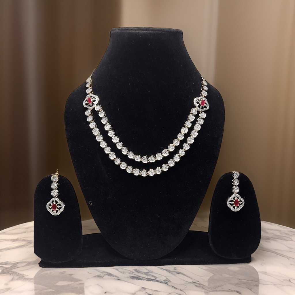 Make a bold statement with our Red Silver American Diamond Necklace. This eye-catching piece features sparkling red American diamond accents that catch the light beautifully. The adjustable length ensures a comfortable fit, making it suitable for all occasions.